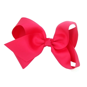 Close-up of a large pink grosgrain ribbon hair bow for babies with a full-bodied design
