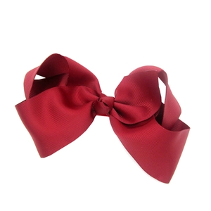Detailed view of 15cm large red grosgrain ribbon bow hair clip on white background