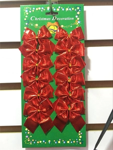Detail view of twelve red glitter Christmas bows neatly arranged on a festive card