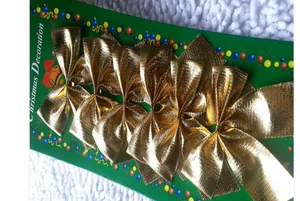 Detail of six glittery gold Christmas bows on festive red and green cardboard packaging