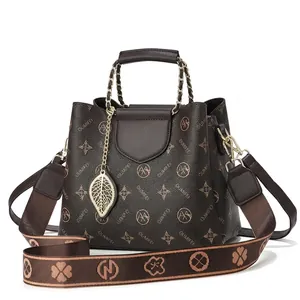 Front and side view of dark brown faux leather crossbody bag with embroidered strap