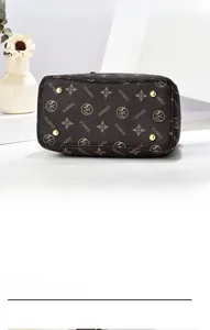 Detailed bottom view of brown monogram handbag showing four golden metal protective feet