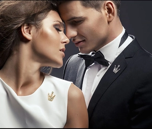 Close-up of elegant crown lapel pins in gold and silver set with sparkling crystals