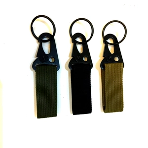 Three tactical nylon carabiner keychains in olive green, black, and khaki with metal rings