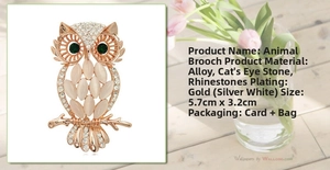 Detail view of owl brooch with pink cat's eye stones and dimensions 5.7cm by 3.2cm