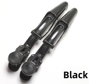 Close-up of two black professional hair alligator clips for sectioning and styling hair
