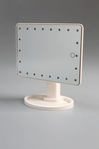 Detail view of cream LED makeup mirror with adjustable stand and storage base tray