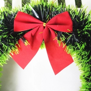 Ghirlanda natalizia con grande fiocco rosso e tinsel verde-nero per decorazioni