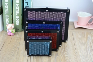 Colorful plastic pin art toys in various sizes stacked on a wooden desk setting