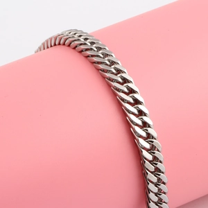 Close-up of 9mm silver Cuban link bracelet on a pink stand showing the polished steel texture