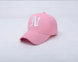 Détail de la casquette rose en coton avec broderie cursive de la lettre N blanche