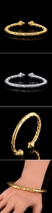 Detail of 18K gold and silver pumpkin bangles showing embossed patterns and hand styling