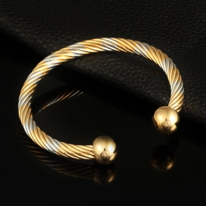 Two-tone twisted cable bangle with gold and silver beads in a polished open design