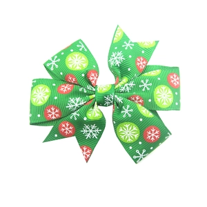 Detail of green ribbed bow hair clip with white snowflakes and festive patterns