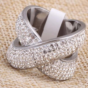 Bague en X croisé en acier 316L avec strass pavés sur un fond en lin naturel