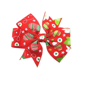 Detail of red Christmas ribbon hair clip with festive glove and snowflake patterns