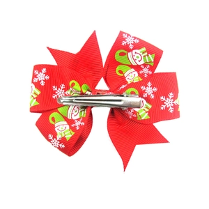 Detail of a red Christmas ribbon bow hair clip with snowman and snowflake patterns