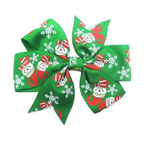 Detail of green Christmas hair bow featuring snowman and white snowflake prints