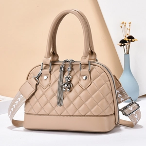 Chic beige quilted crossbody bag with circular handle and metal bear charm accessory