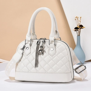 White quilted shell handbag with metal bear charm and detachable wide woven strap