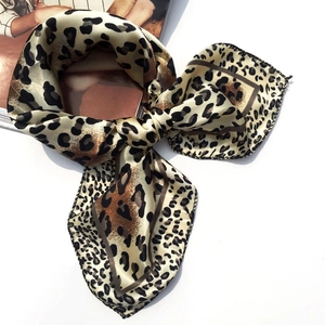 Elegant leopard print silk scarf tied in a bow on a white background for women
