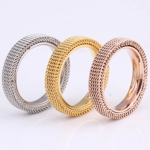 Detailed macro of 4mm three-color mesh stainless steel rings with hollow weave texture