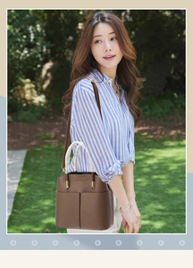 Detail of dark brown lychee leather crossbody bag with gold hardware and shoulder strap