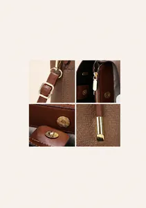 Macro shot of dark brown lychee leather texture and golden metal hardware on crossbody bag