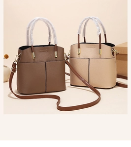 Detail of dark brown and beige tote bags with lychee pattern faux leather and gold hardware