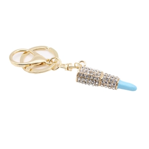 Detailed view of gold rhinestone lipstick keychain with vibrant blue crystal accents