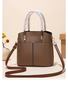 Close-up of deep brown lychee texture leather bucket bag with front pocket detail