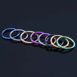 Macro shot of eight colorful G23 titanium seamless rings in blue, gold and rainbow finishes