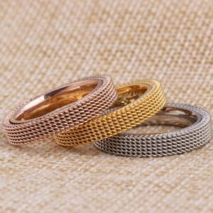 Close-up of triple stacked 4mm mesh texture rings in gold, silver, and rose gold finishes