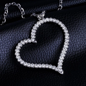 Sparkling silver heart pendant necklace with full crystal inlay on black leather background