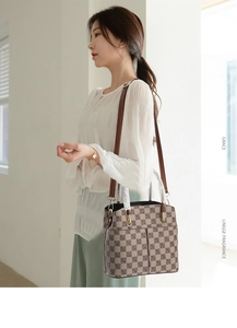 Detail of vintage brown plaid handbag featuring dual front pockets and gold hardware