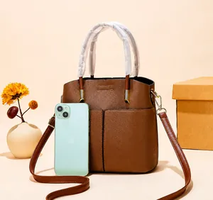 Size comparison of brown litchi pattern leather handbag next to a smartphone