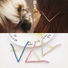 Dettaglio di fermagli per capelli a V con strass scintillanti in vari colori vivaci