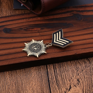 Macro detail of vintage metal brooch featuring engraved star emblem and V-shaped badge