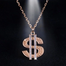 Macro detail of rose gold dollar sign pendant with sparkling pavé stones on black background