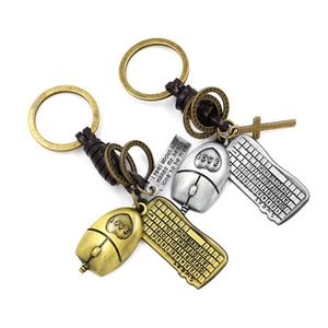 Detail of vintage metal keyboard and mouse keychains with leather cord on white background