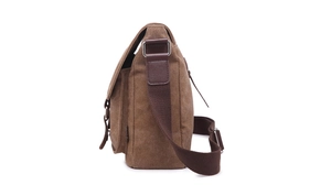 Side view of brown canvas messenger bag showing metal buckles and leather accents