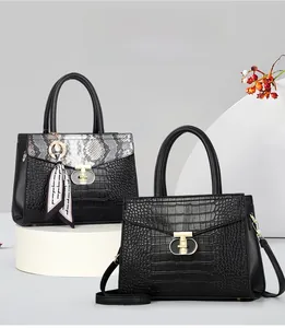 Détail de sacs à main en cuir noir avec fermoir en T doré et foulard décoratif