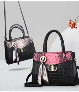 Détail de la texture crocodile noir et rabat serpent rose sur sac à main avec fermoir doré