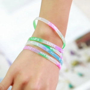 Nahaufnahme von bunten Silikonarmbändern mit Farbverlauf und motivierendem Aufdruck