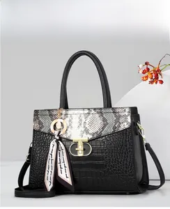 Détail du sac bandoulière noir avec texture serpent et crocodile et fermoir doré