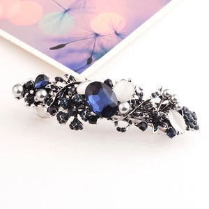 Detailed view of vintage silver hair clip with deep blue gemstones and faux pearls