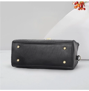 Détail du fond de sac noir en cuir crocodile avec des clous de protection dorés