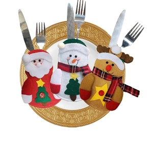 Three Christmas cutlery holders featuring Santa, Snowman, and Reindeer on a gold-patterned plate