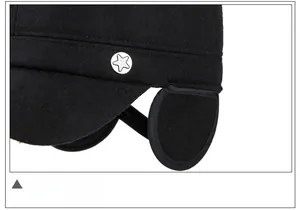 Detail of black wool winter cap featuring a silver star emblem and folding earflaps