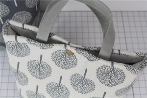 Detail view of cotton linen lunch bag showing tree pattern and vintage copper buckle closure